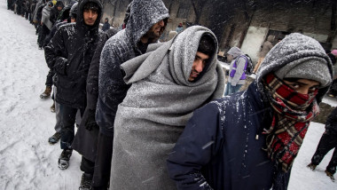 Migranți în frig și ninsoare.