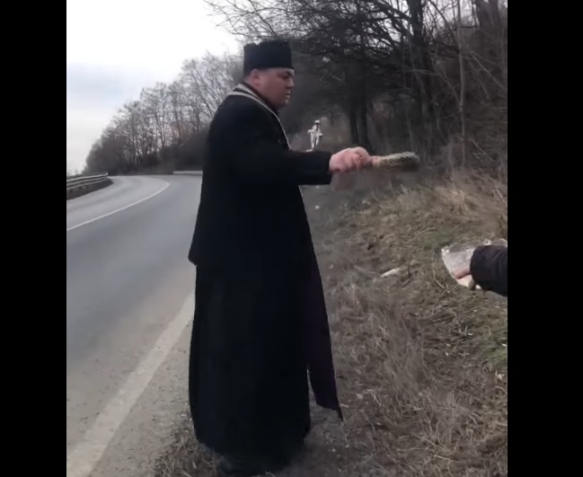 Imagini virale cu un preot care sfințește "curba morții" de pe DN11