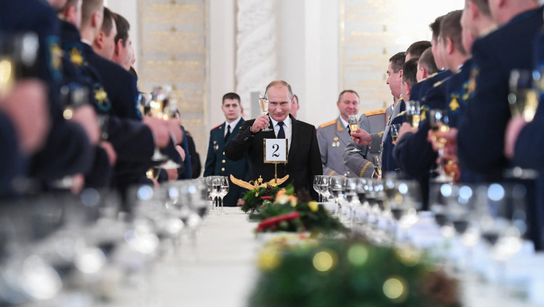 Preşedintele rus Vladimir Putin toastează în cadrul unei ceremonii la Kremlin, în prezenţa ministrului apărării, Serghei Şoigu, şi a ofiţerilor armatei ruse. Putin ține în mână un pahar de șampanie