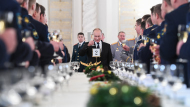 Preşedintele rus Vladimir Putin toastează în cadrul unei ceremonii la Kremlin, în prezenţa ministrului apărării, Serghei Şoigu, şi a ofiţerilor armatei ruse. Putin ține în mână un pahar de șampanie
