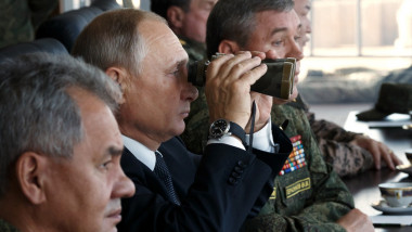 Putin privește prin binoclu flancat de oficiali de rang înalt