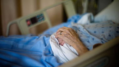 Femeie în vârstă într-un pat de spital.