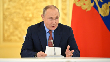 Vladimir Putin la microfon, cu un bilet in mana