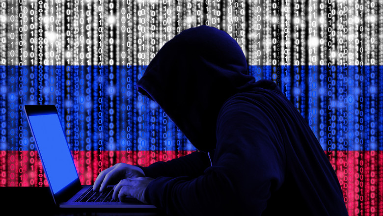 Un hacker cu drapelul Rusiei pe fundal.