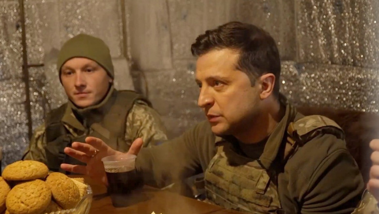 Volodimir Zelenski stă la masă într-un adăpost și vorbește cu militari.