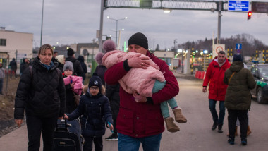 Refugiati ucraineni cu copii in brate
