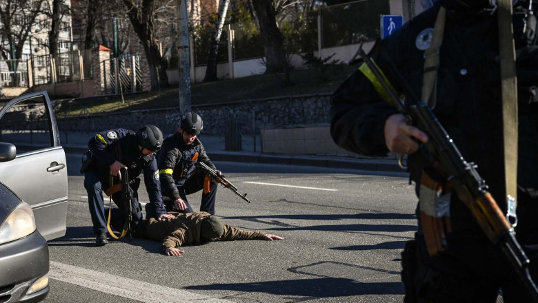 Ukrainian policemen stop cars to control people as they look for suspicious men, on February 27, 2022 in a street of Kyiv