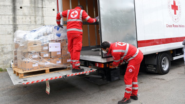 voluntari crucea rosie descarca medicamente dintr-un camion