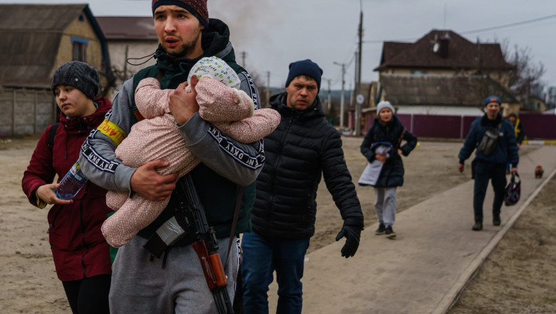 O familie cu un copil mic fuge din calea atacurilor rusești la Irpin.