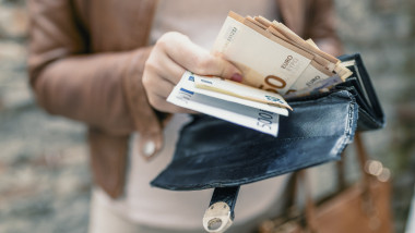 femeie care numara bancnote de euro scoase din portofel