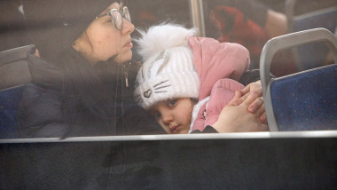 O femeie își tine copilul în brațe în timp ce se refugiază din calea războiului din Ucraina