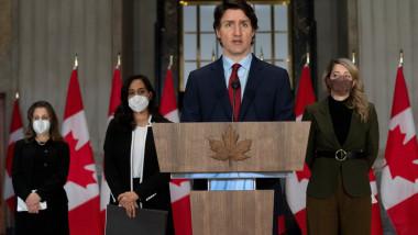 premierul canadian justin trudeau face declaatii de presa cu steagurile canadei in spate