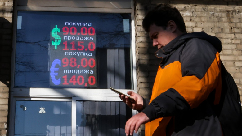 barbat cu telefonul in mana in fata unei case de schimb valutar in rusia