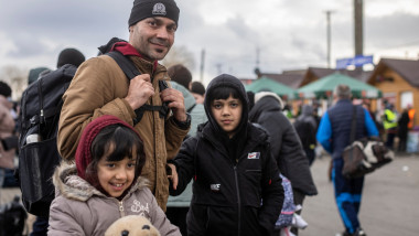 refugiat afgan cu rucsac in spate si cei doi copii al lui, la granita ucraina polonia