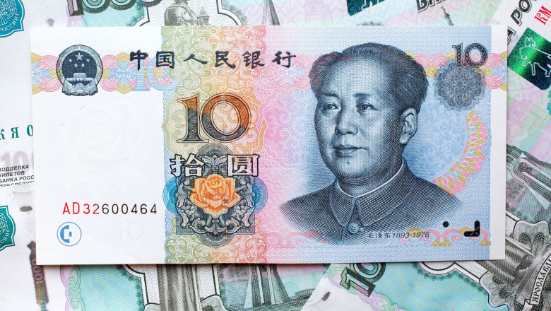 10 Yuan banknote with Mao Zedong and 1000 Russian Rubles banknotes as background