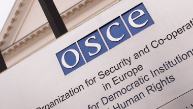 Placă cu numele OSCE la intrarea în instituție.