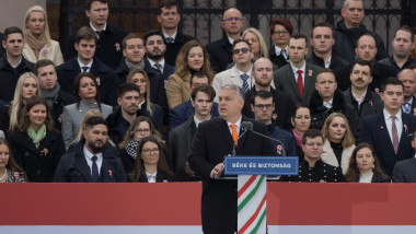 Viktor Orban la pupitru cu un grup de oameni într-o gradenă în spatele lui