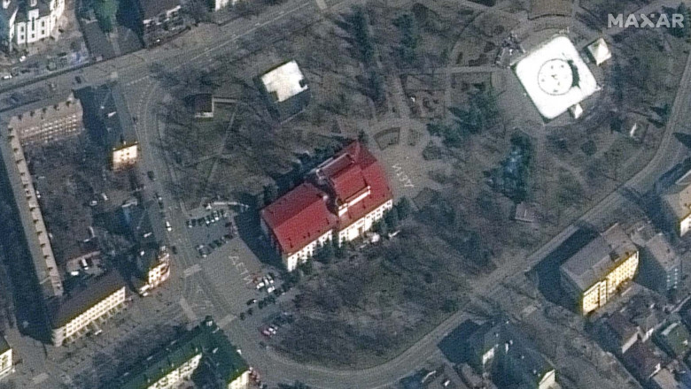 Clădirea teatrului din Mariupol, fotografiată din spațiu de compania Maxar. În fața și în spatele clădirii se vede scris cu litere mari cuvântul COPII (дети)