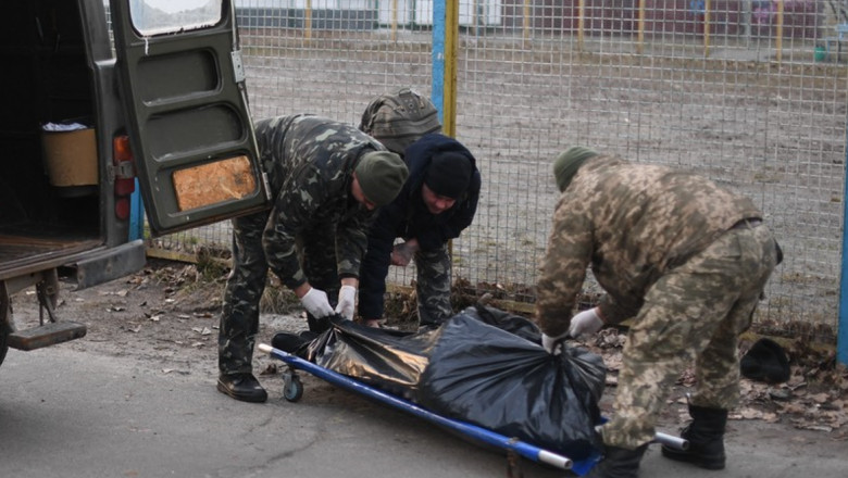 O persoană decedată este luată de pe stradă de militari ucraineni.