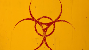 Red biohazard sign over yellow background