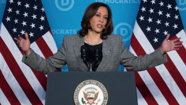 kamala harris se adreseza unei reuniuni a democratilor facand un gest cu bratele deschise