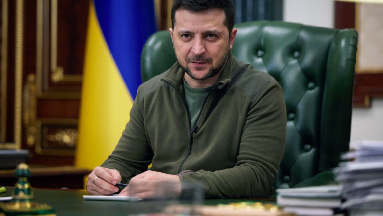 Volodimir Zelenski la birou cu un steag al Ucrainei în spate