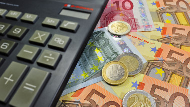 Euro banknotes, coins and pocket calculator