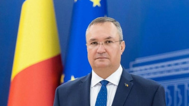 Nicolae Ciucă lângă drapele României și UE.
