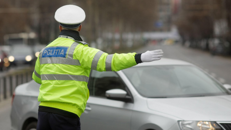 Bucharest, Romania - February 2, 2022: Romanian road police agent manages the traffic on a busy street on a winter day.