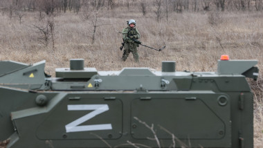 soldat rus cu echipament si un vehicul militar cu litera z