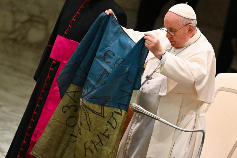 Papa Francisc ținând în mâini un steag al Ucrainei