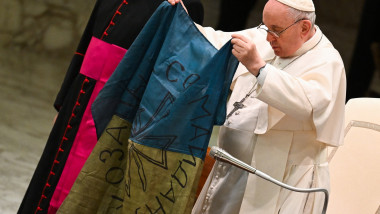 Papa Francisc ținând în mâini un steag al Ucrainei