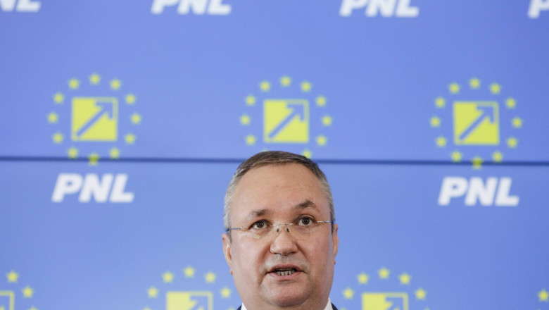 președintele PNL Nicolae Ciucă, în fața unu panou/banner inscripționat cu PNL