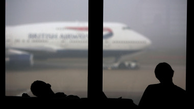 Sleeping British Airways passengers at London Heathrow wait for flights delayed by fog