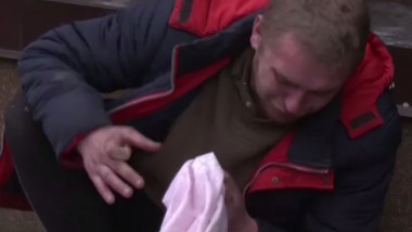 Un bărbat din Ucraina plânge lângă fratele său ucis de ruși.