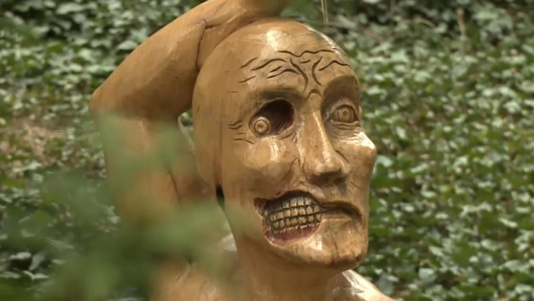 sculptura a capului unui om unde pe jumatate din fata i se vad dintii ca unui craniu