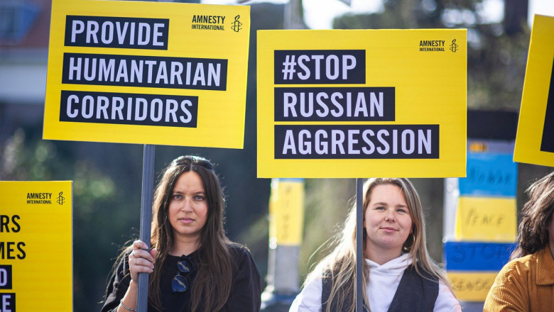 Protest al două tinere cu pancarte de la Amnesty International.