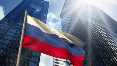 Drapel al Rusiei în fața a două clădiri de birouri.