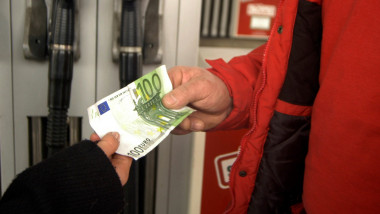 oameni la pompa cu o bancnota de 100 de euro