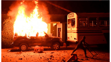 Mașină a poliției în flăcări și un protestatar aruncă cu obiecte