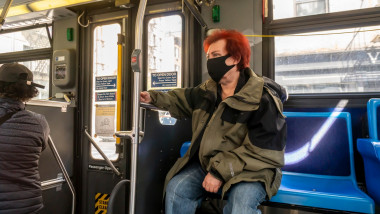 Femeie din New York, cu mască, ăntr-un autobuz.