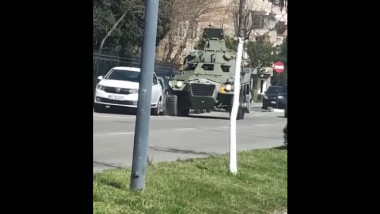 vehicul militar verde pe strada in rm valcea, masini parcate la bordura