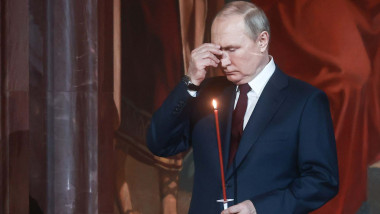 Vladimir Putin isi face cruce, cu lumanare in mana, la slujba de Înviere.