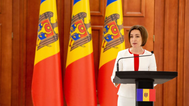 Președinta Republicii Moldova, Maia Sandu. sustine o declaratie la pupitru cu steaguri ale moldovvei in spate