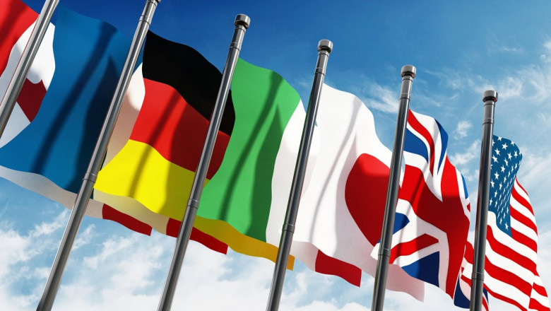 Waving G7 country flags on blue sky background