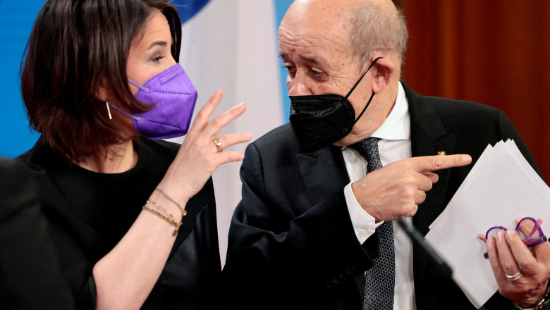 annalena baerbock discuta cu jean-yves le drian ambii avand masti de protectie