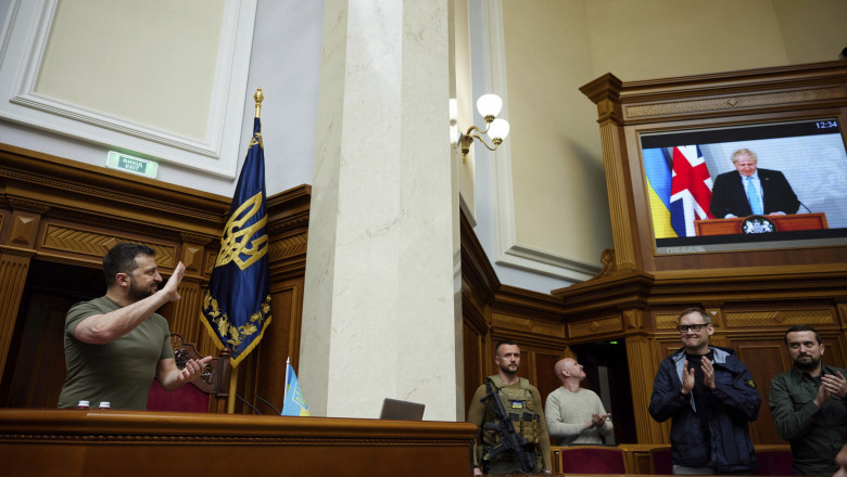 volodimir zelenski îl aplaudă in parlament in picioare, alături de alti parlamentari ucraineni, pe premierul boris johnson, care s-a adresat lor prin videoconferință