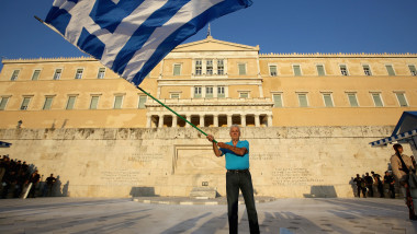 grecia om cu steag in fata parlamentului 1007GettyImages-480064338-3