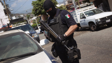 Polițist din Mexic inarmmat langa masina de politie