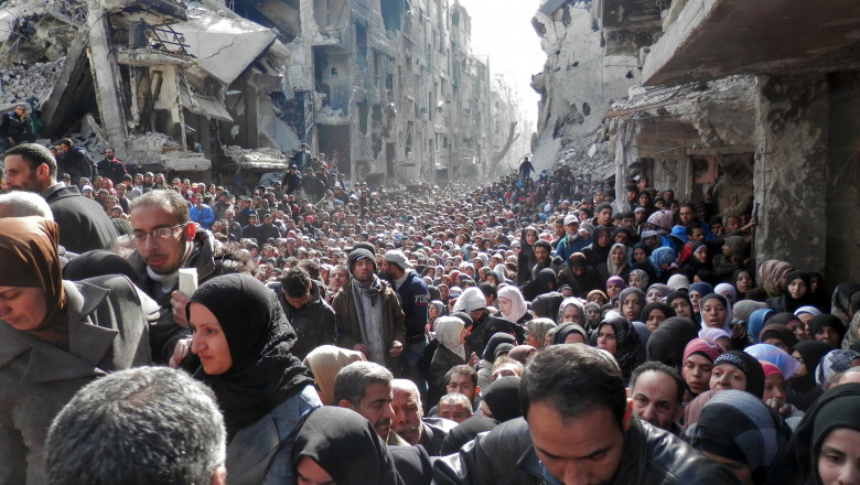 aglomeratie de oameni printre ruinele din siria.